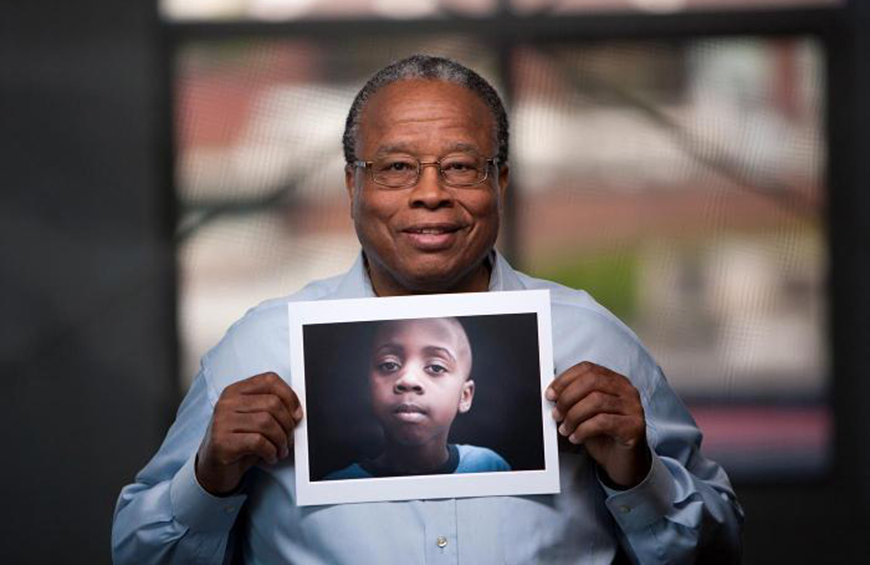 Image of a Court Appointed Special Advocate holding photo of young boy